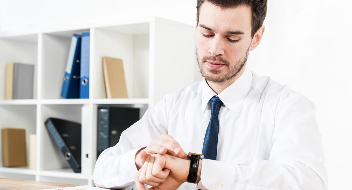 Trabajador mirando el reloj. Foto: Freepik.