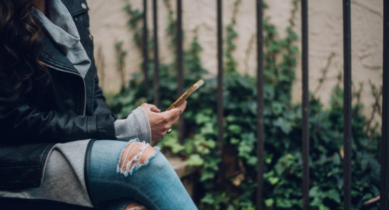 Mujer con celular. Foto: Unsplash.