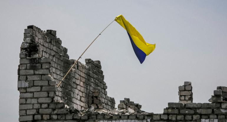 La bandera ucraniana, en la cima de una casa destruida en  Neskuchne. Foto: Reuters.