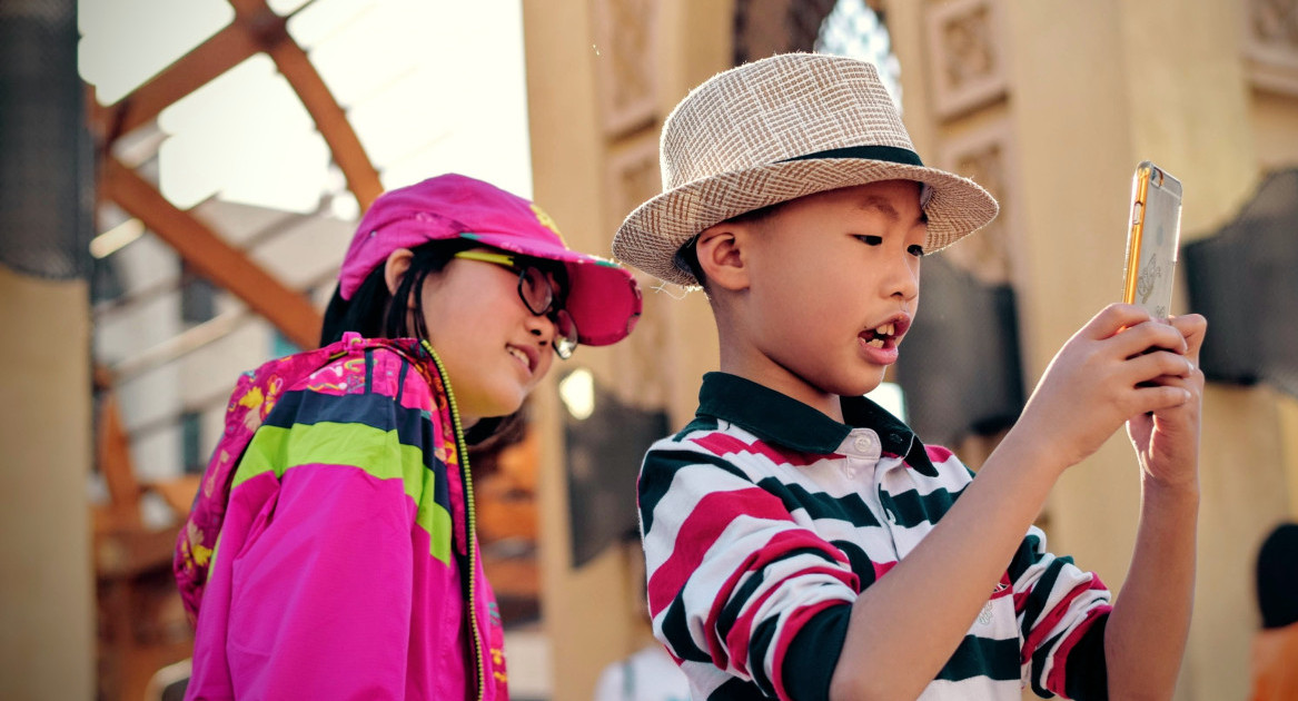 Niño con celular. Foto: Unsplash.