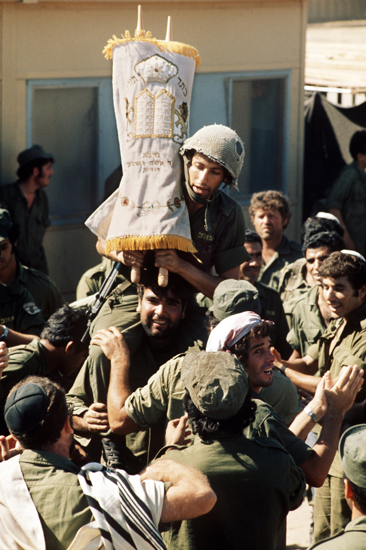 Guerra Yom Kippur. Un soldado israelí sostiene un rollo de la Torá el último día de la Fiesta de los Tabernáculos (Sukkot) en el frente de batalla en la península del Sinaí. Reuters