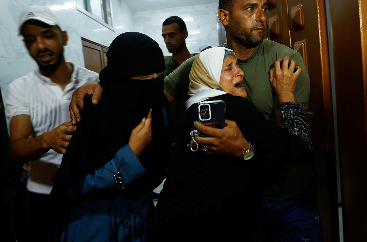 Familia palestina tras el asesinato de su hijo en la frontera con Gaza en manos de las fuerzas israelíes. Foto: Reuters.