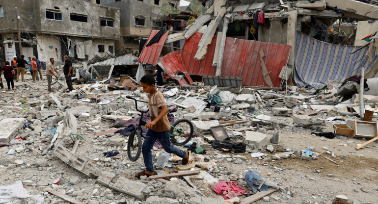 Un niño camina en el lugar de un ataque aéreo israelí contra una casa, mientras continúa el conflicto entre Israel y el grupo islamista palestino Hamás, en Jan Yunis, en el sur de la Franja de Gaz. Reuters