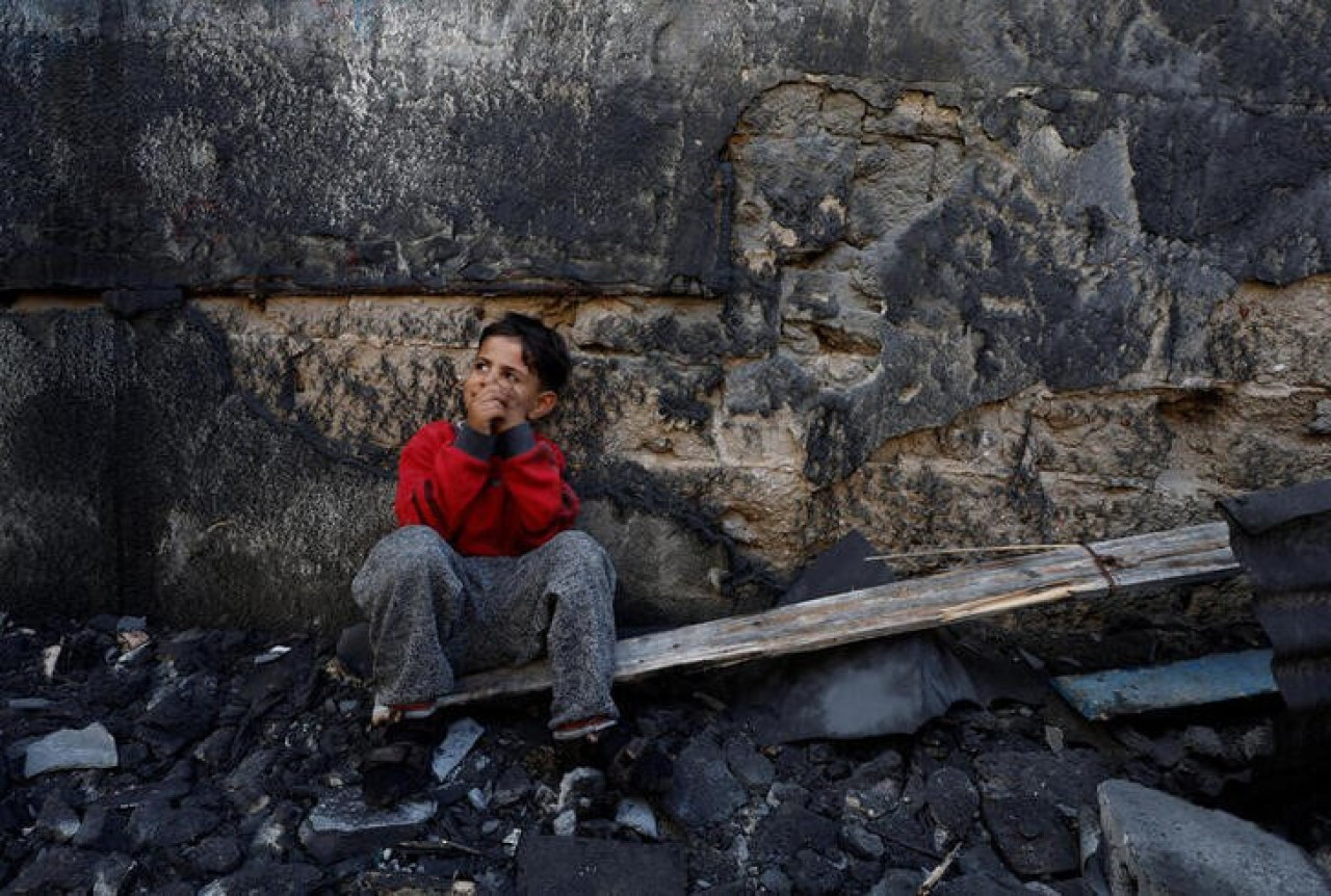 un niño palestino sentado junto a unos escombros en Jan Yunis, en el sur de la Franja de Gaza.. Reuters