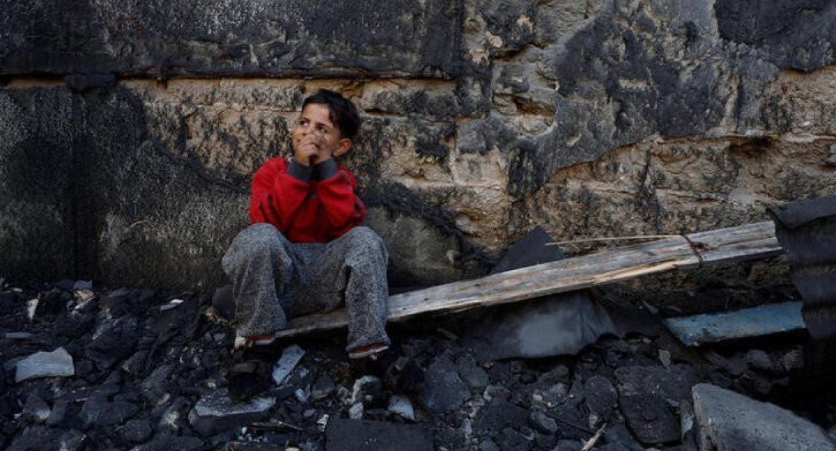 un niño palestino sentado junto a unos escombros en Jan Yunis, en el sur de la Franja de Gaza.. Reuters