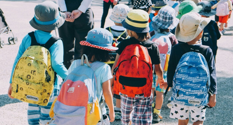 Niños pequeños con mochilas. Foto: Unsplash.