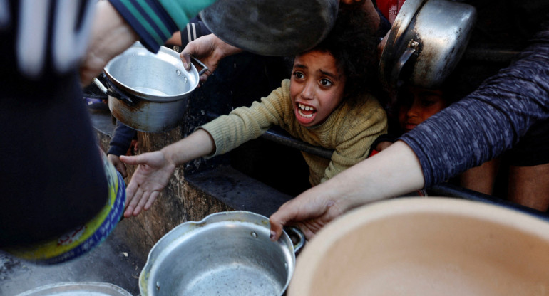 Niños palestinos piden ayuda humanitaria en Gaza. Foto: Reuters.