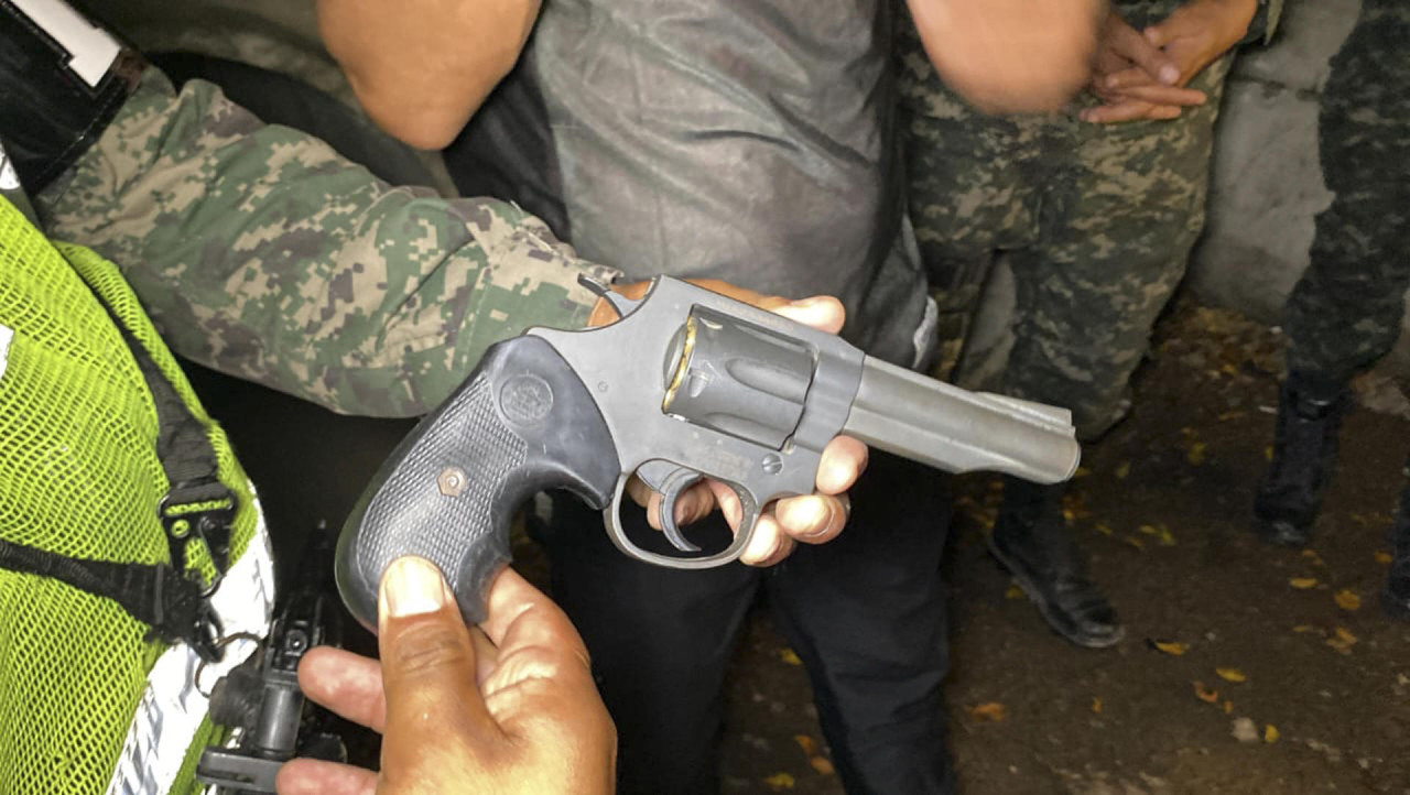 Un integrante de la Policía Militar del Orden Publico sostiene un arma incautada. Foto: EFE