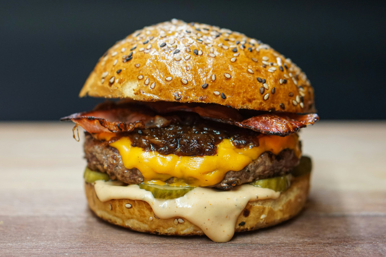 Cebolla caramelizada en la hamburguesa. Foto: Unsplash.