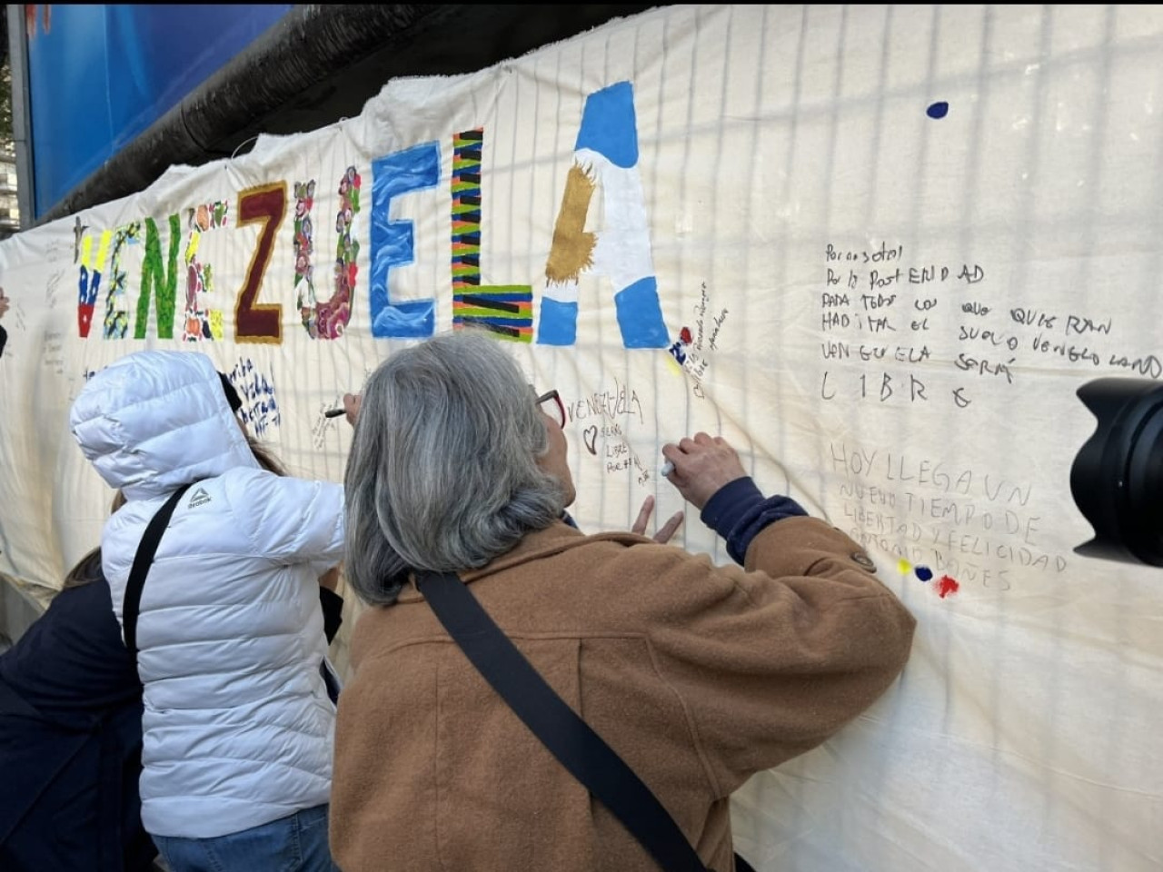 Venezolanos en Argentina firman el mural después de votar. Foto: Gabriel Bastidas