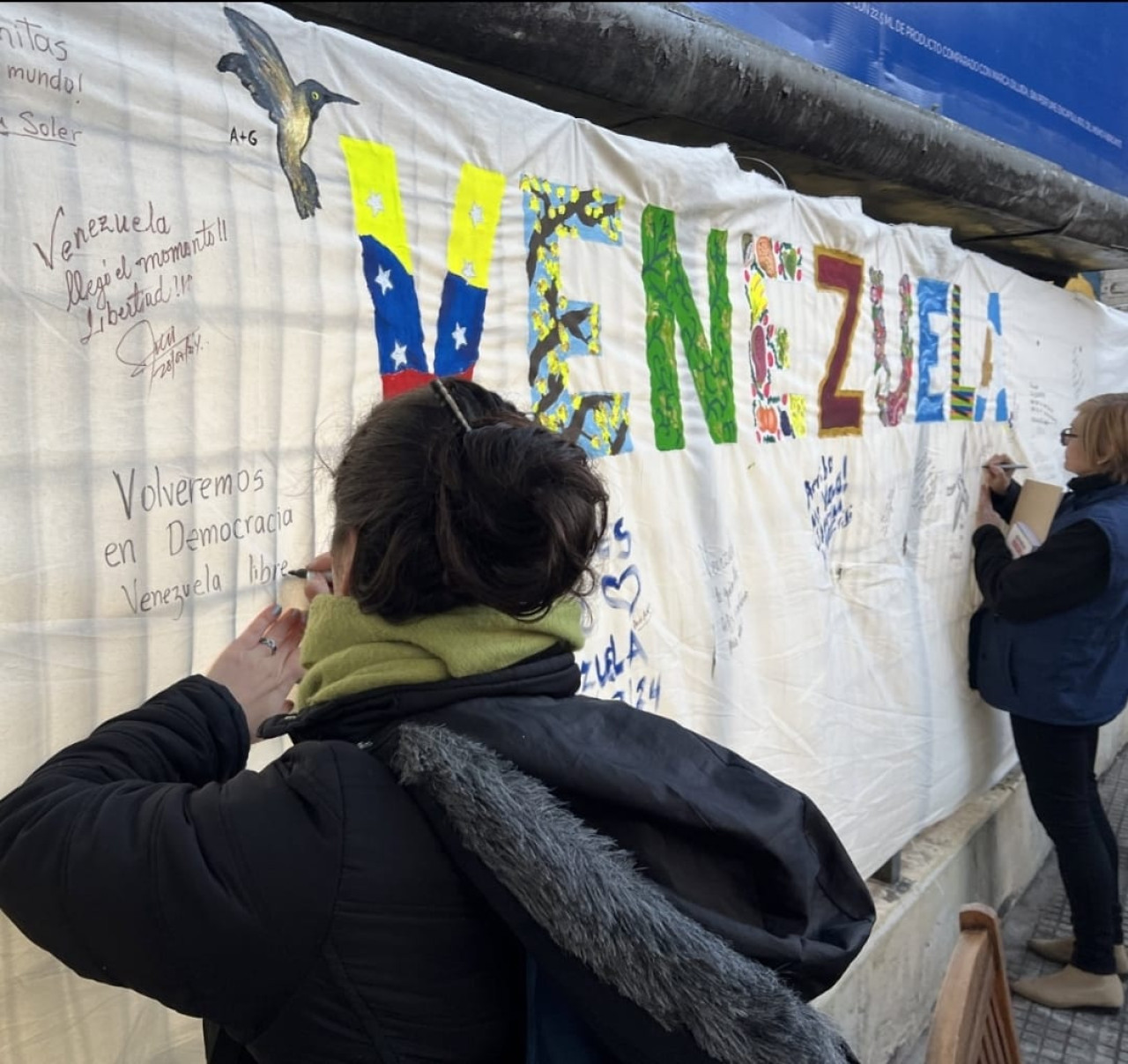 Venezolanos en Argentina firman el mural después de votar. Foto: Gabriel Bastidas