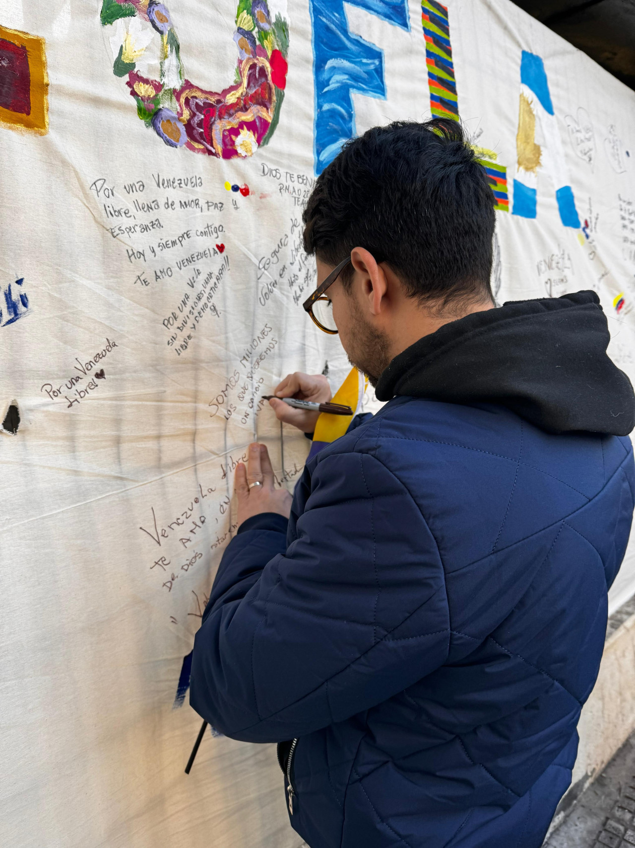 Venezolanos en Argentina firman el mural después de votar. Foto: Gabriel Bastidas