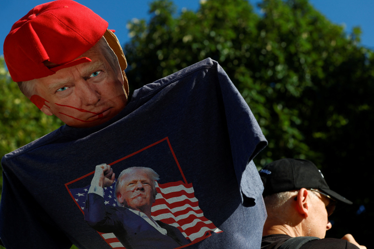 Un hombre sostiene una figura de cartón del candidato presidencial republicano y expresidente estadounidense Donald Trump cerca del Centro Nacional de la Constitución. Foto: Reuters.