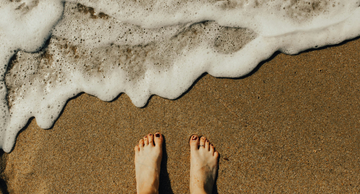 Los pies se ensucian en la playa. Foto: Unsplash.