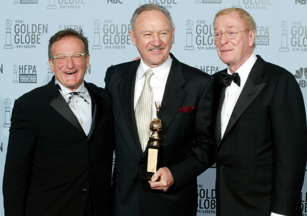 Gene Hackman sostiene el premio Cecil B. DeMille que le entregaron Robin Williams (izq.) y Michael Caine. REUTERS.Andy Clark. Foto de archivo 2003